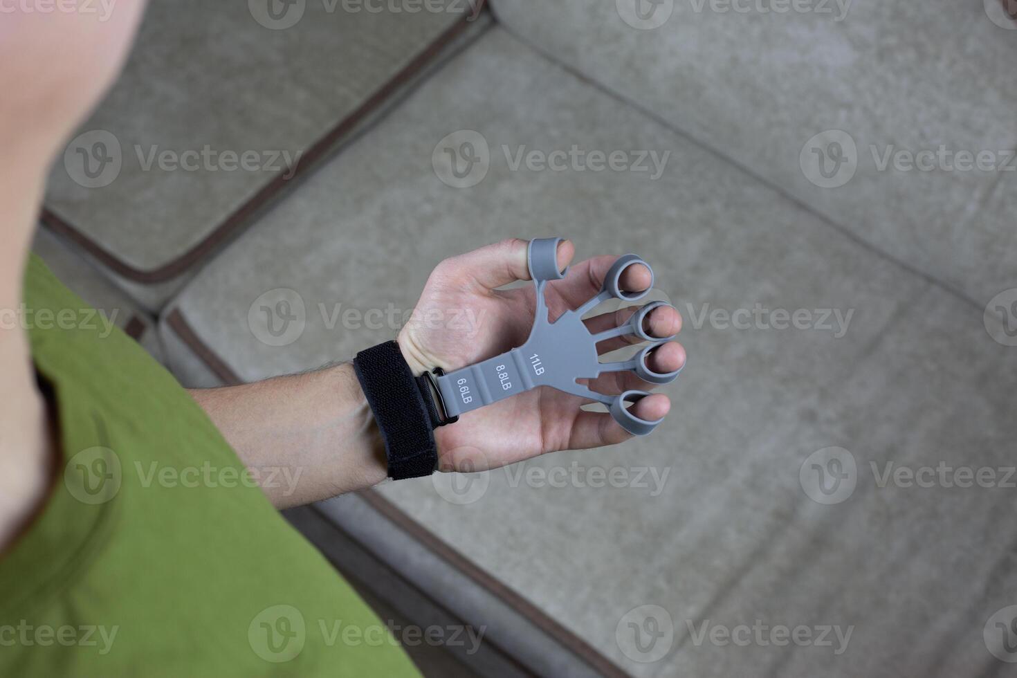 Hand held finger trainer worn on the fingers with clamp on the hand to improve joint mobility and strengthen hand muscles photo