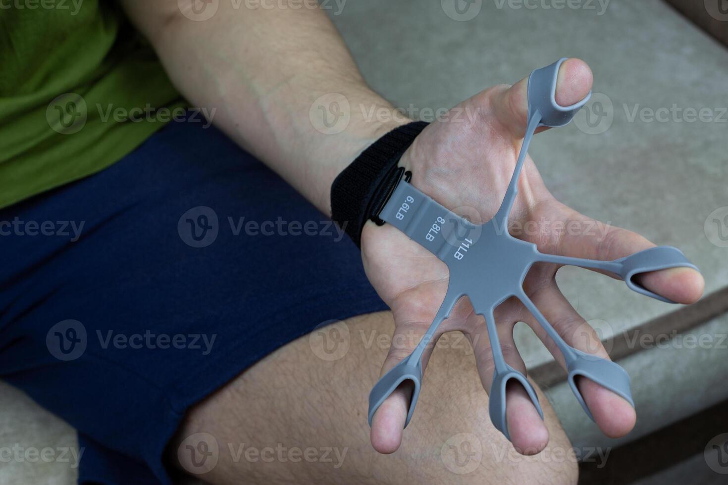 Finger trainer in stretched position while performing an exercise to develop hand and finger strength photo