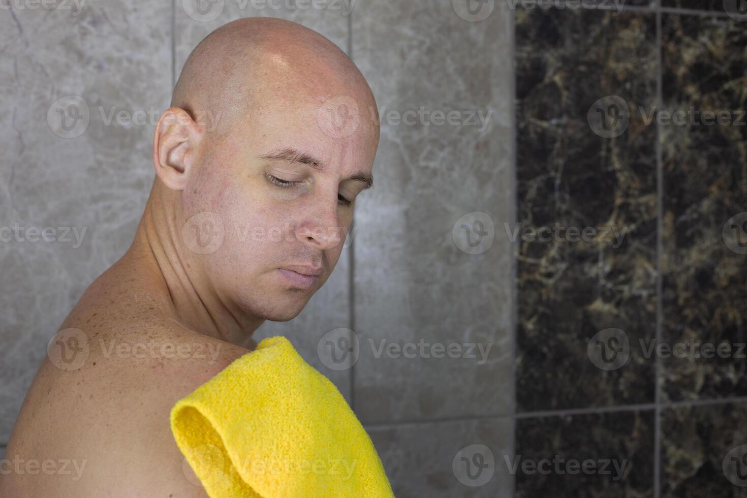Man rubs his shoulder with washcloth in the shower, care and hygiene of body and skin at home photo