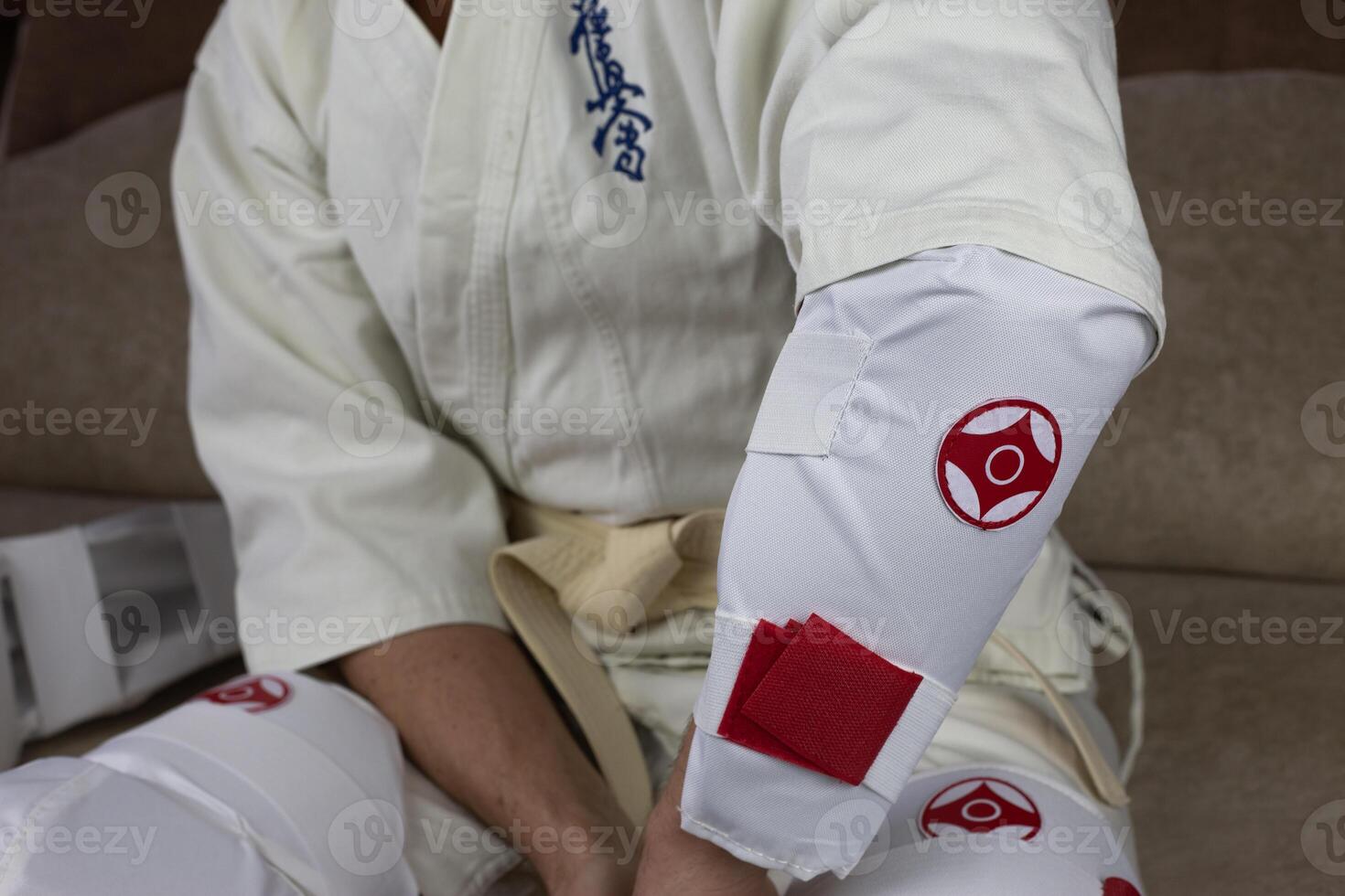 Kyokushinkai karate athlete wears elbow protection, protective equipment for martial arts sparring, health protection in karate photo