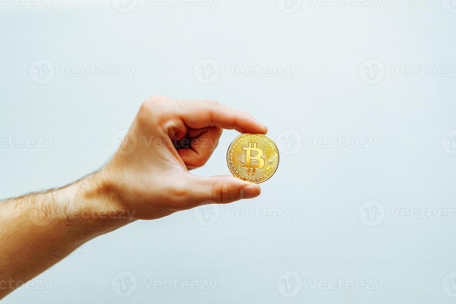 Bitcoin in hand on a light background. photo