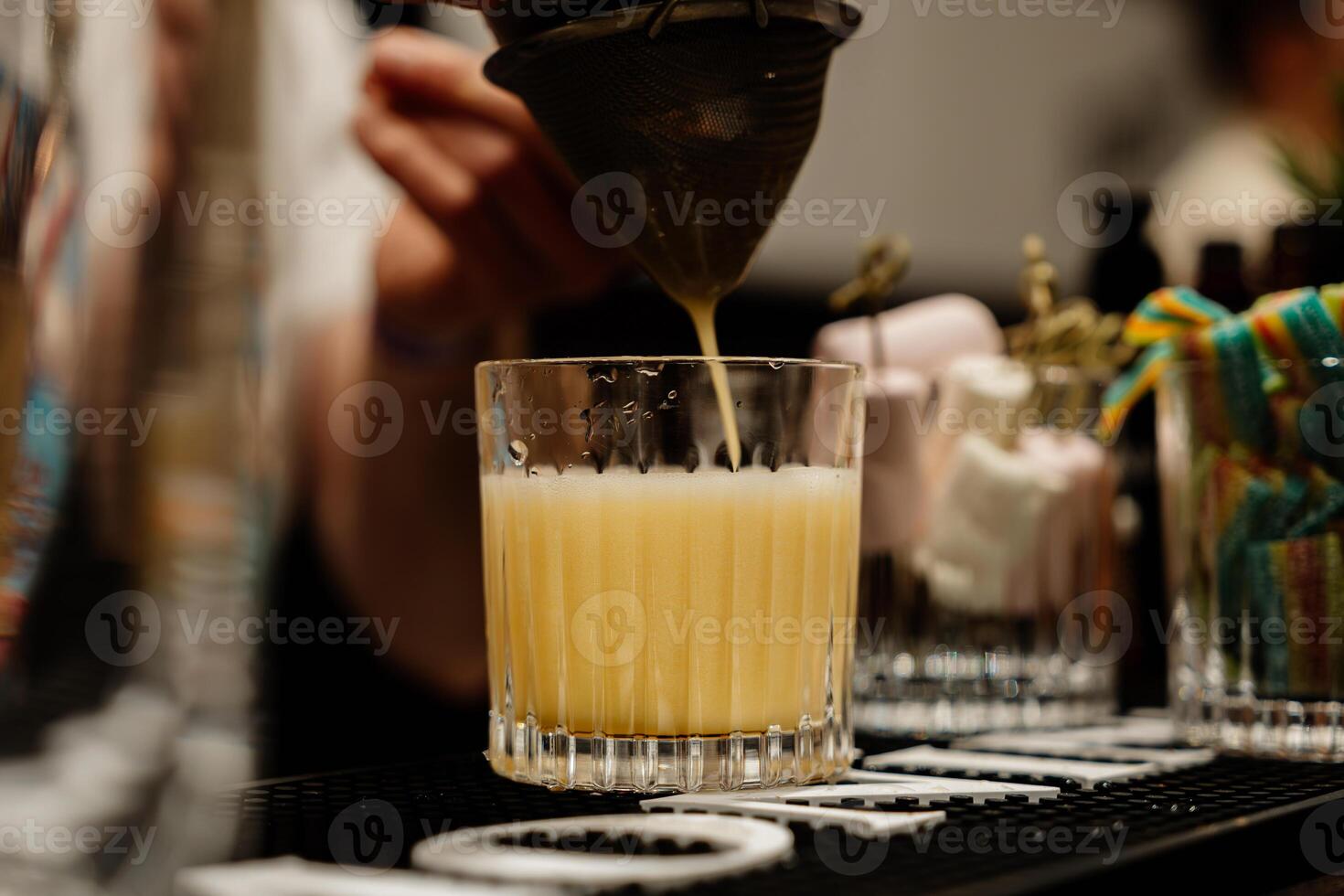 The bartender prepares a yellow cocktail. photo