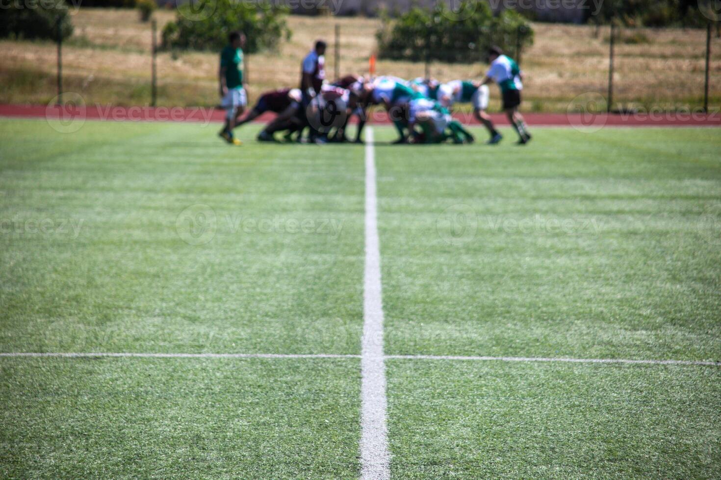 Group of men playing rugby on grass field, tackling and passing ball in action-packed match. photo