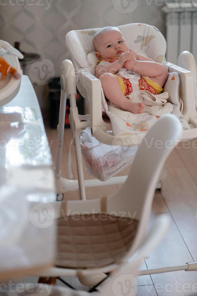 cute six months old baby sitting in the baby bath chair photo