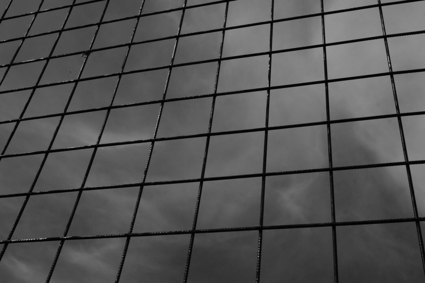 Black and white iron fence with rectangular weave. Monochrome of exterior on public park. Graphic Resources. Monochrome Background Photography. Light Shadow Photography Concept. photo
