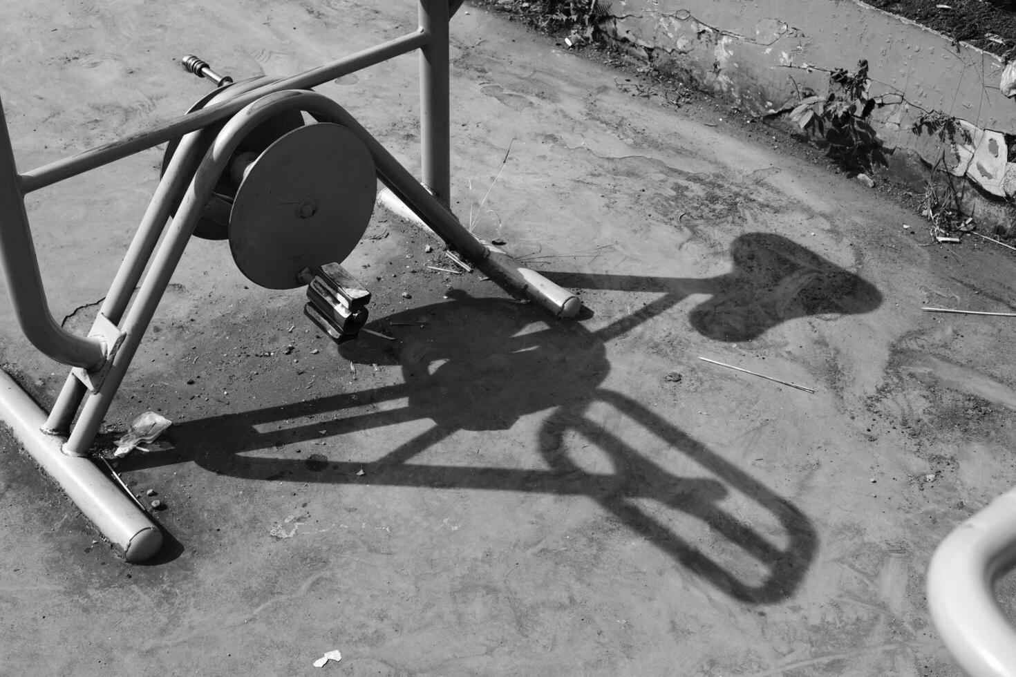 Black and white outdoor stationary bike. Monochrome of exterior on public park. Graphic Resources. Monochrome Background Photography. Light Shadow Photography Concept. photo
