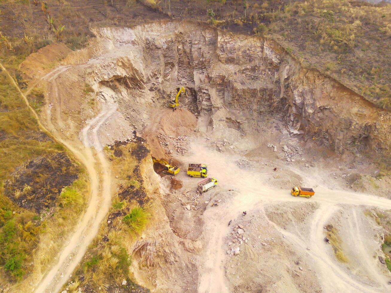 Aerial Photography. Aerial Drone view of landscape view of a group of trucks carrying rocks on Mount Pangradinan, Cikancung - Bandung, Indonesia. Industrial transportation photo