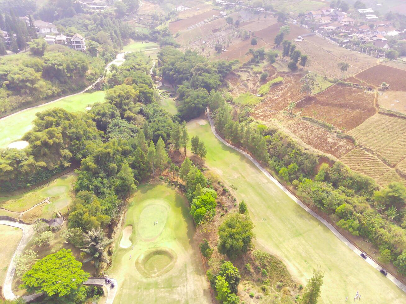 Bird's eye view of a Golf Courses area with cityscape and trees, Bojong Koneng - Bandung, Indonesia. Drone Photography, Aerial Photography, Landscape, Sport Fields, Green Field aerial photo