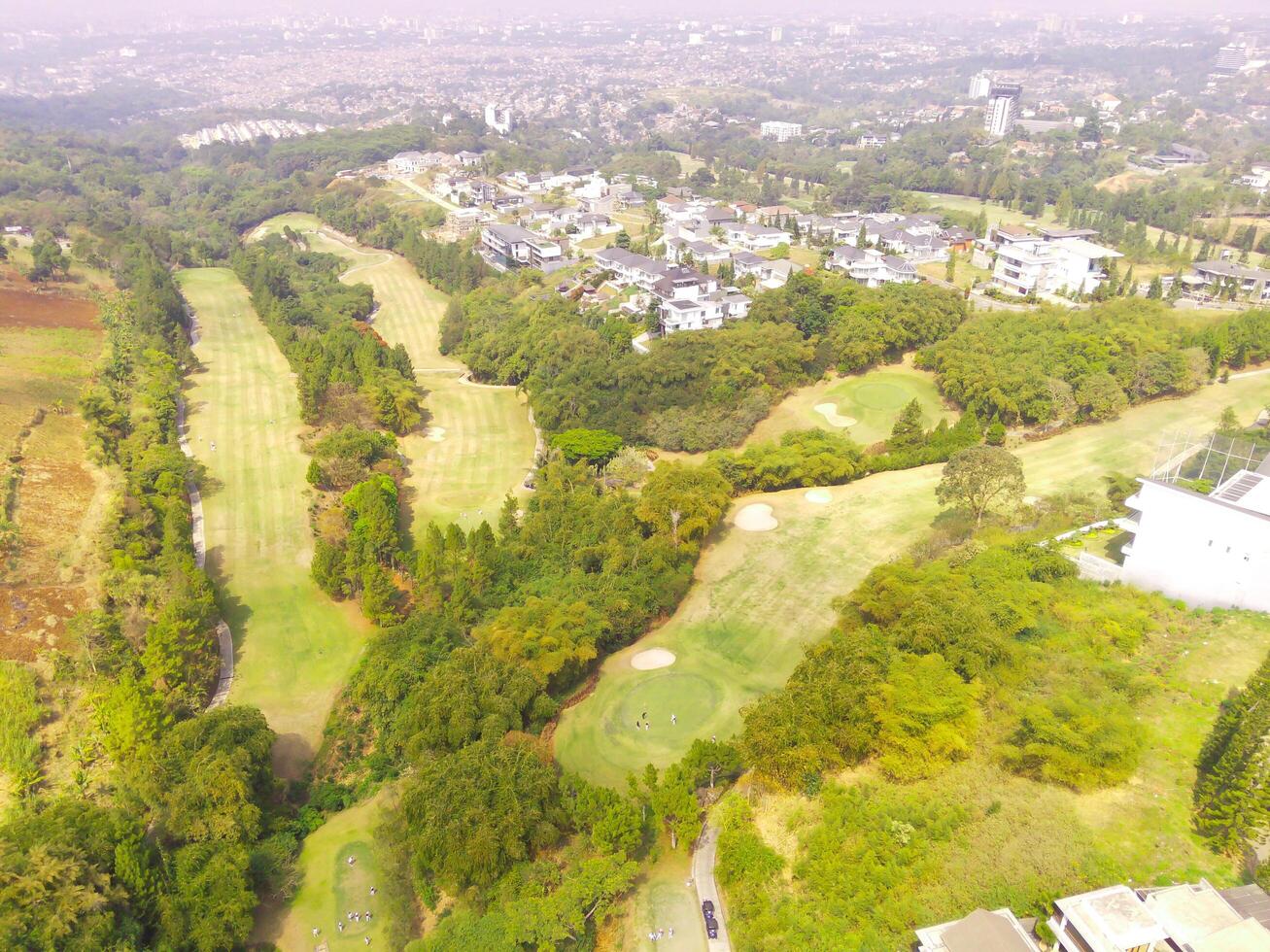 Bird's eye view of a Golf Courses area with cityscape and trees, Bojong Koneng - Bandung, Indonesia. Drone Photography, Aerial Photography, Landscape, Sport Fields, Green Field aerial photo