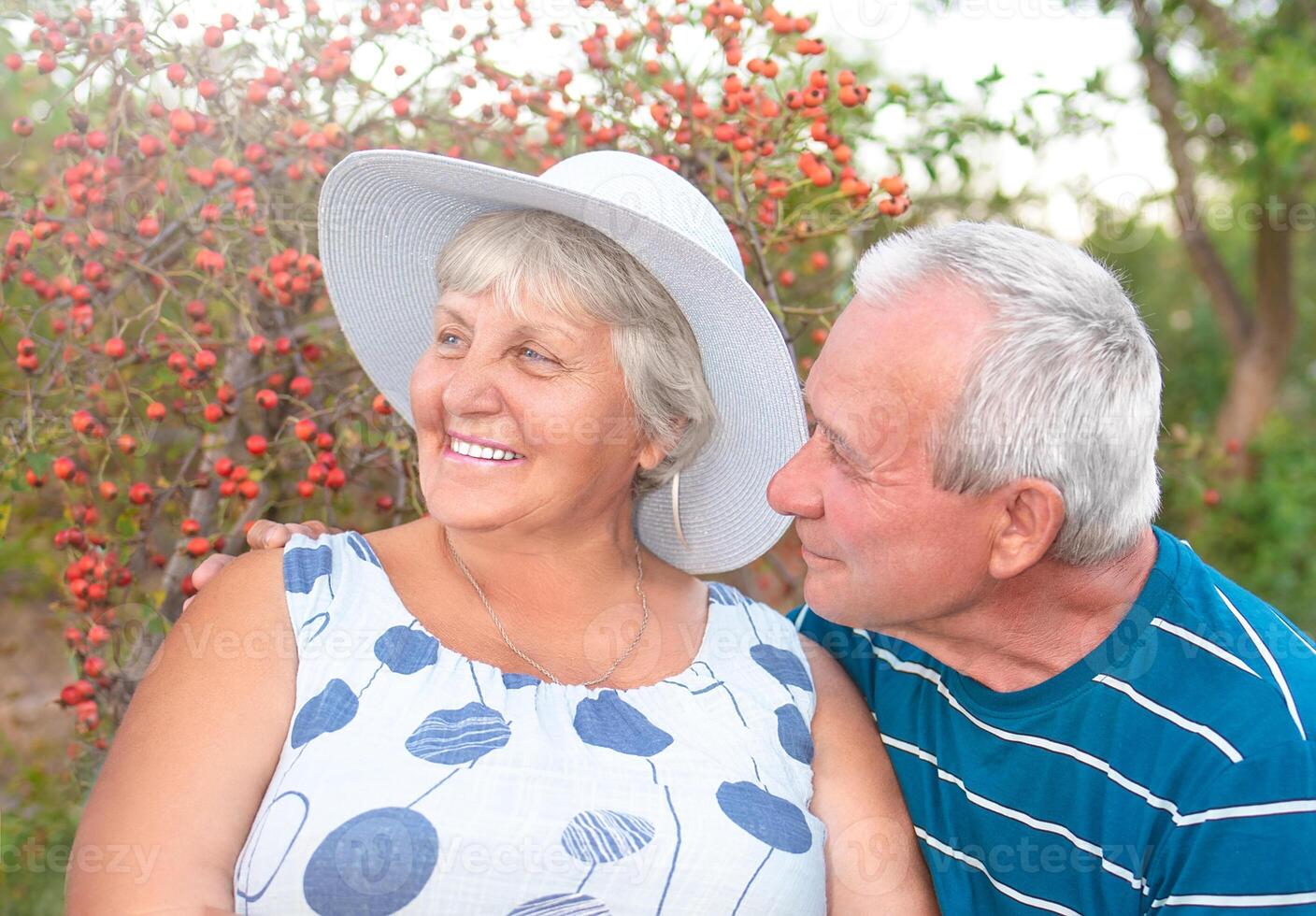 auténtico al aire libre Disparo de envejecimiento Pareja teniendo divertido en el jardín y bendito con amor. durante su juego hombre es molesto a Beso su esposa y ella es riendo fuera alto. amor y familia concepto. foto