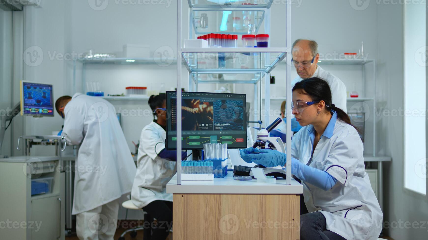 Professional scientists team preparing vaccine against new virus in modern equipped laboratory. Multiethnic team examining treatment evolution using high tech, chemistry tools for scientific research photo