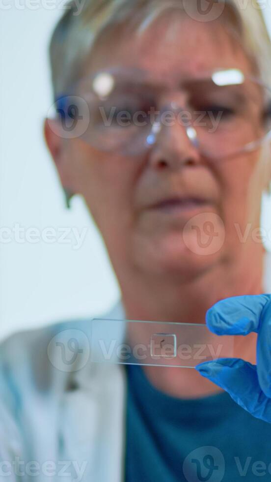 Close up of woman lab engineer analysing virus samples in modern equipped laboratory. Senior doctor working with various bacteria, tissue and blood tests, pharmaceutical research for antibiotics photo