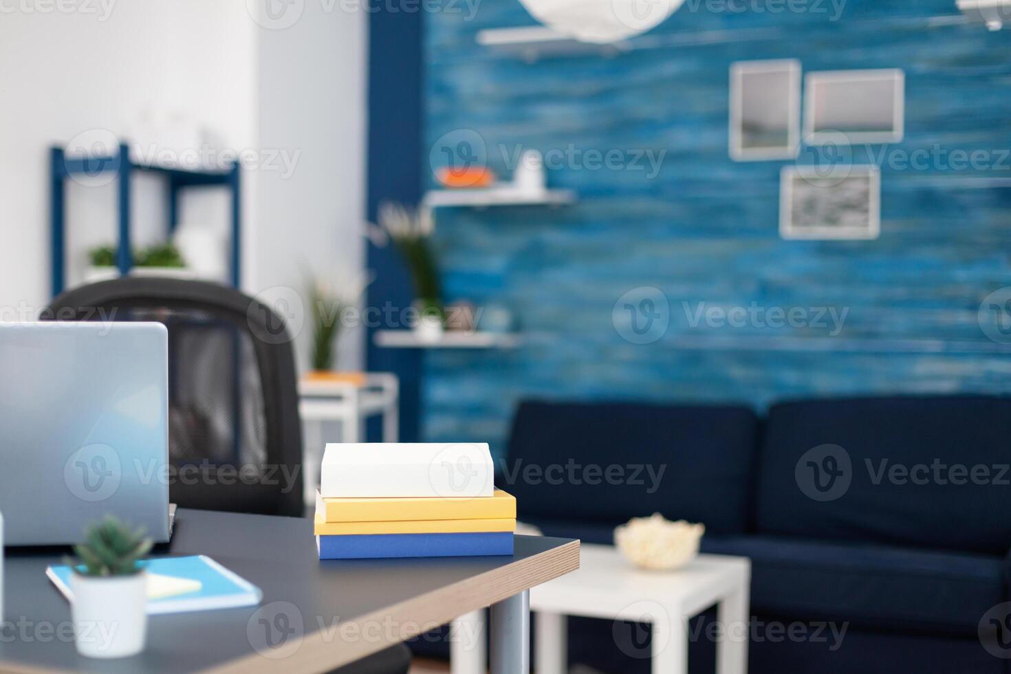 Stack of books on modern furniture in empty office. Cozy home living room with nobody in it with beautiful interior design. photo