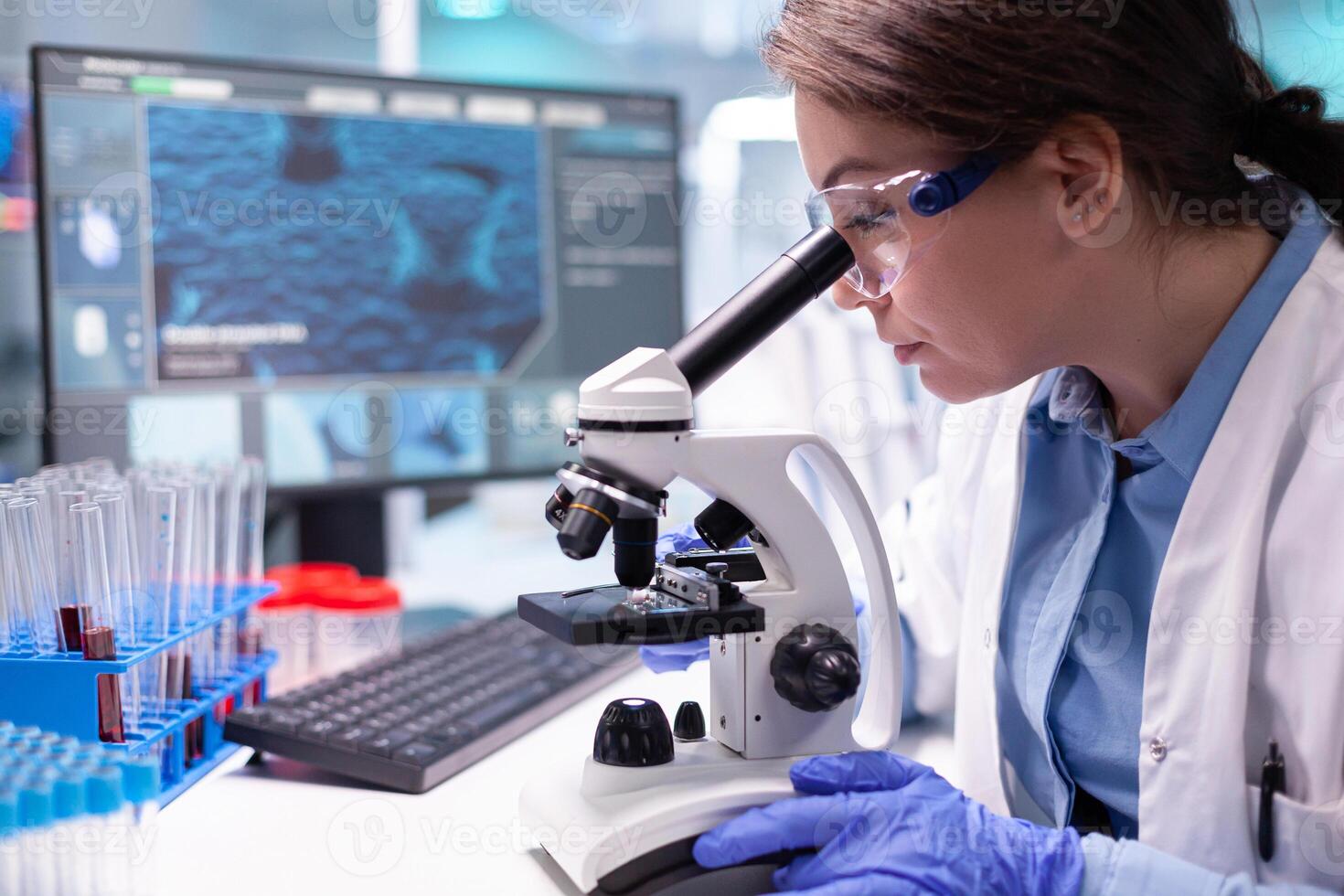 Pharmacy scientist working with professional microscope in technology lab. Modern laboratory with research equipment for virus study and vaccine science development. photo