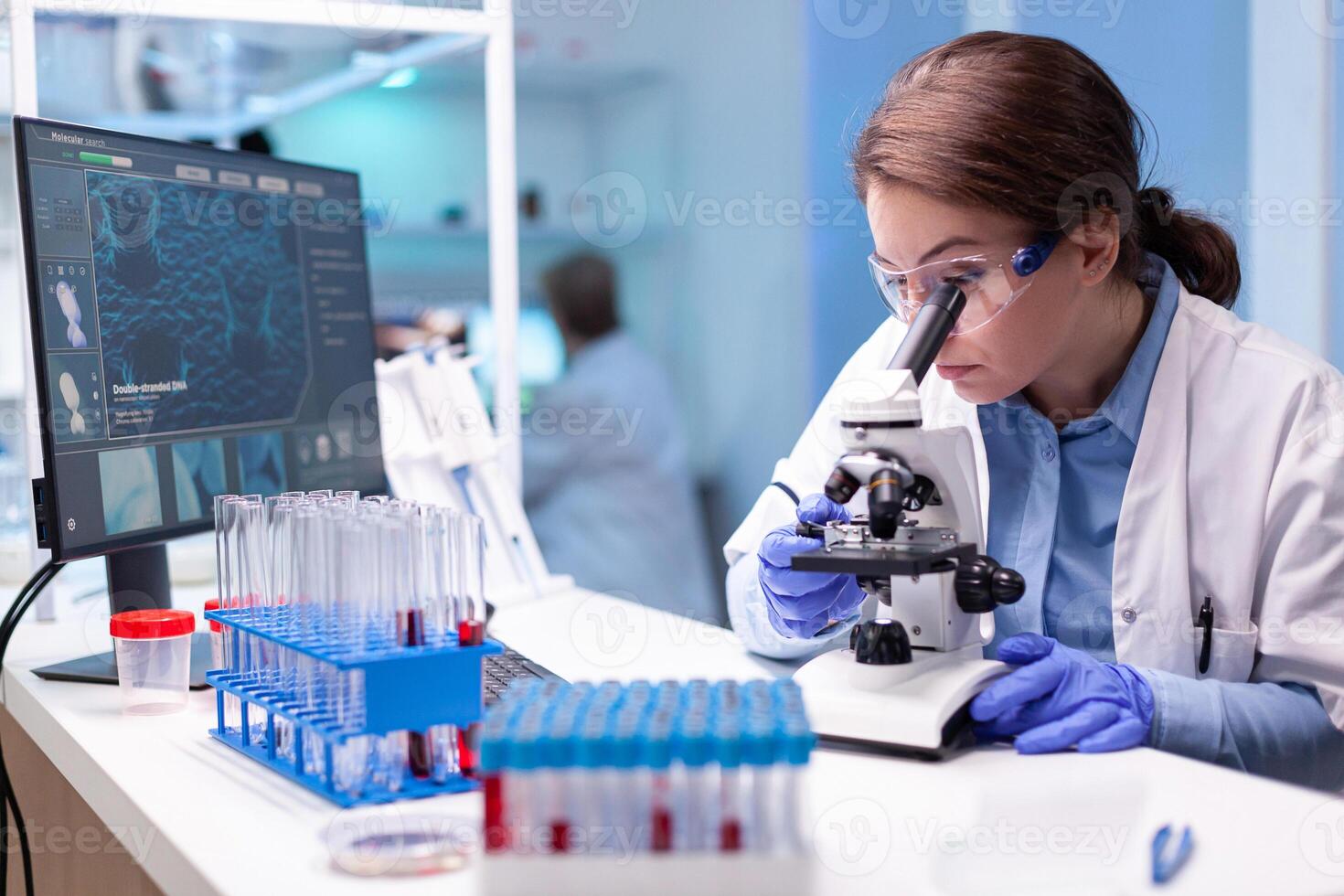 Scientist looking into microscope in virus research laboratory with pharmacy development equipment. Woman working on science vaccine chemistry experiment in modern lab, analyzing pharmaceutical work photo