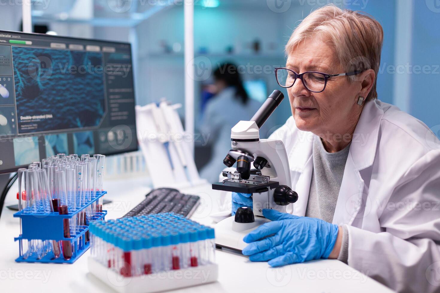Pharmacy senior scientist working with professional microscope in clinic discovery. Modern lab with research equipment for virus study and vaccine science development photo