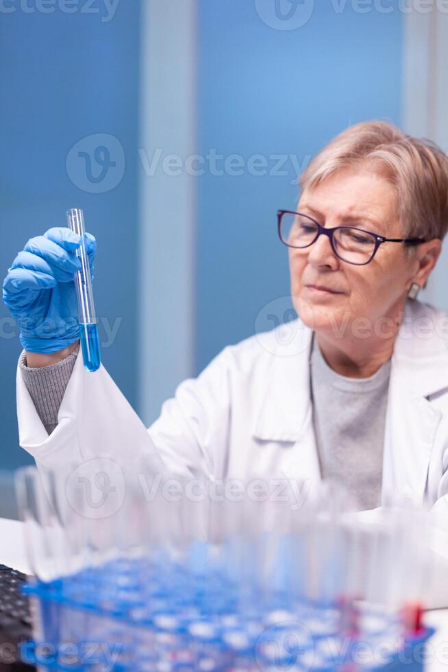 Senior doctor discovering genetic infection and analysing a test tube for medical expertise. Pharmaceutical scientist in research laboratory work with professional technology equipment for healdcare development photo