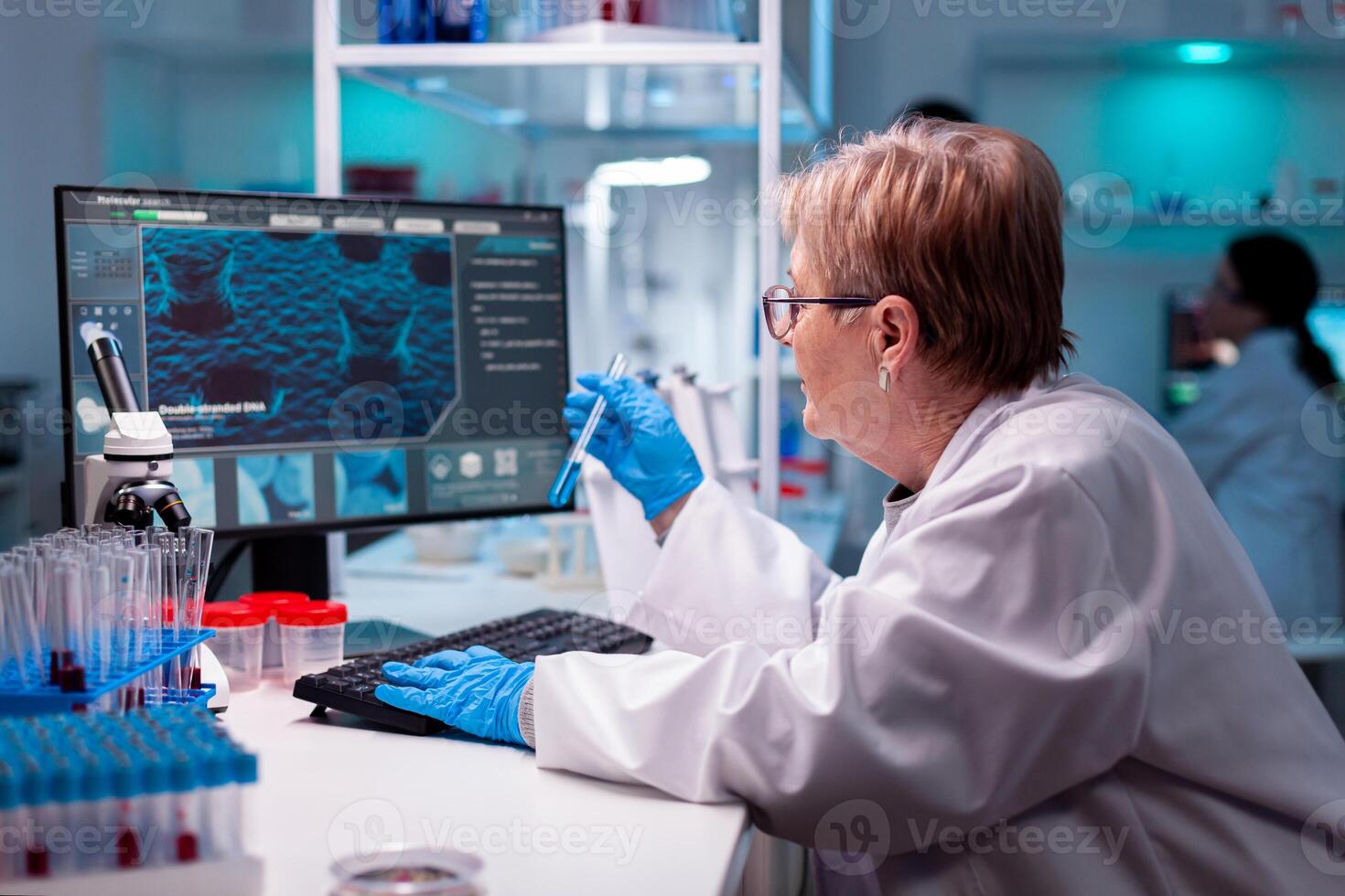 Biotechnologist senior scientist researching with test tube in pharma lab. Chemist researcher working in laboratory with test tube to discovery vaccine against coronavirus. photo