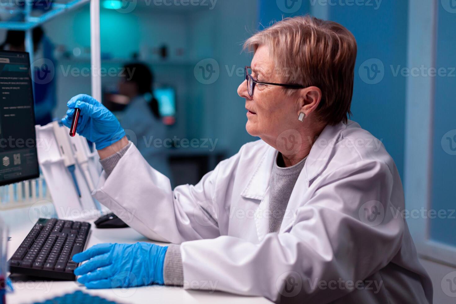 Scientist analysing blood test sample in medical facility hospital. Researcher in medicine lab working with professional technology equipment for diagnostics development and healthcare. photo