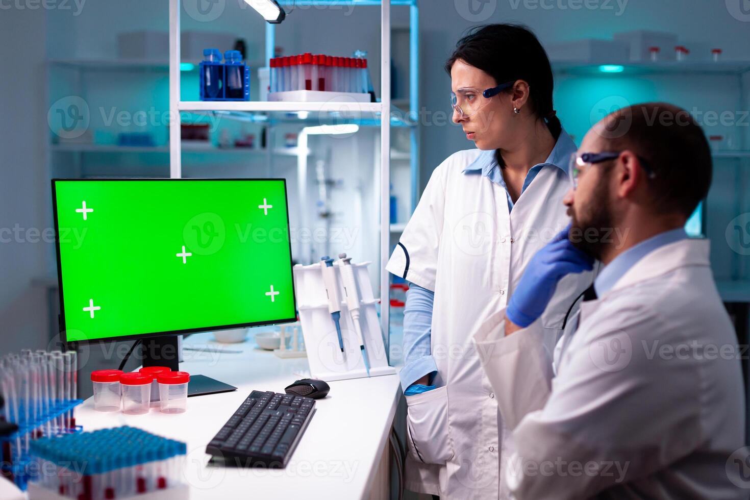 Team of scientist working and analyzing using computer with green screen in clinic, chemical specialist. Doctors specialists discovering scientifc experiment with technology equipment industry. photo