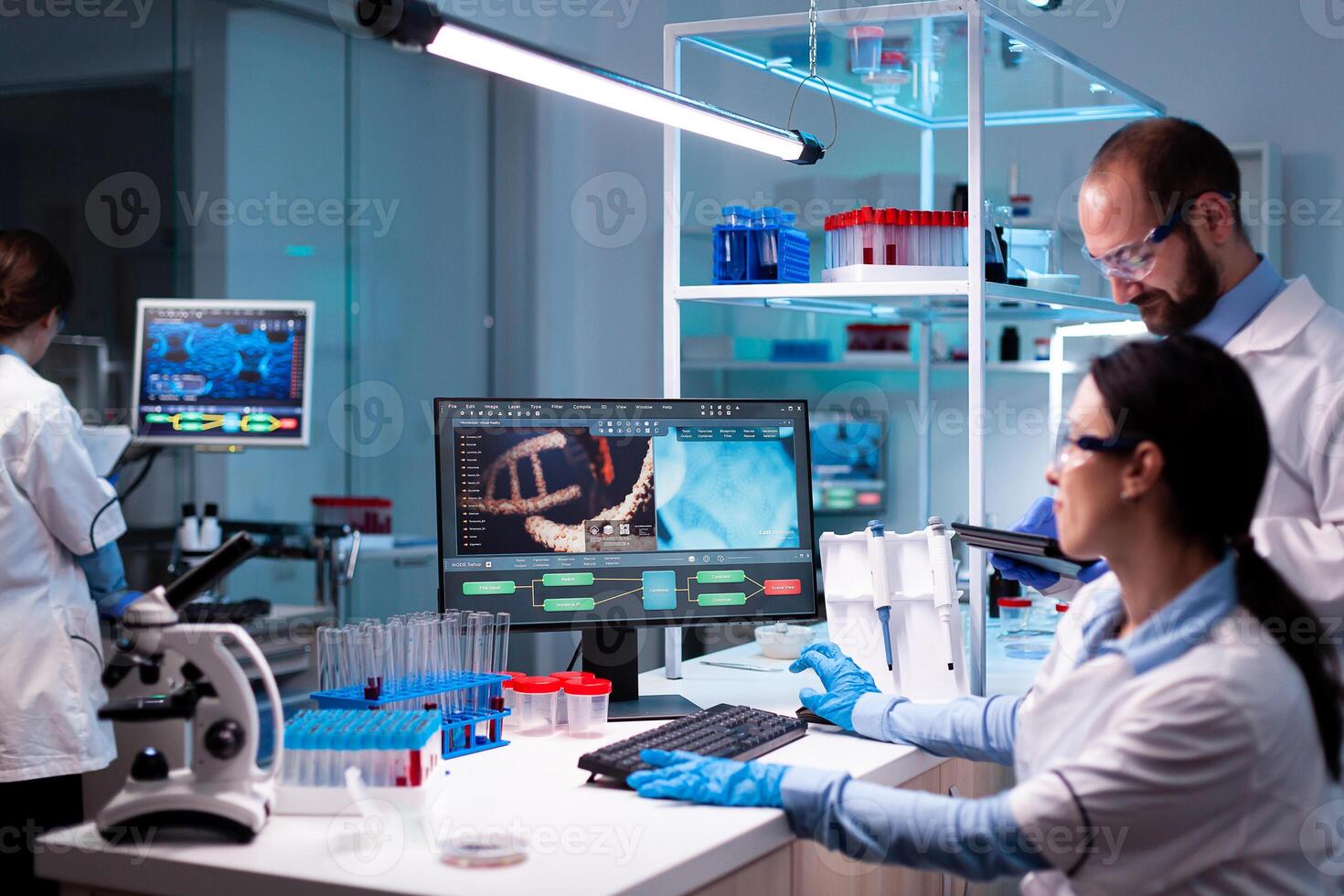 Team of scientist analyzing vaccine for virus in healthcare facility chemistry experiment. Doctors specialists discussing innovative treatment using high tech technology equipment for healthcare. photo