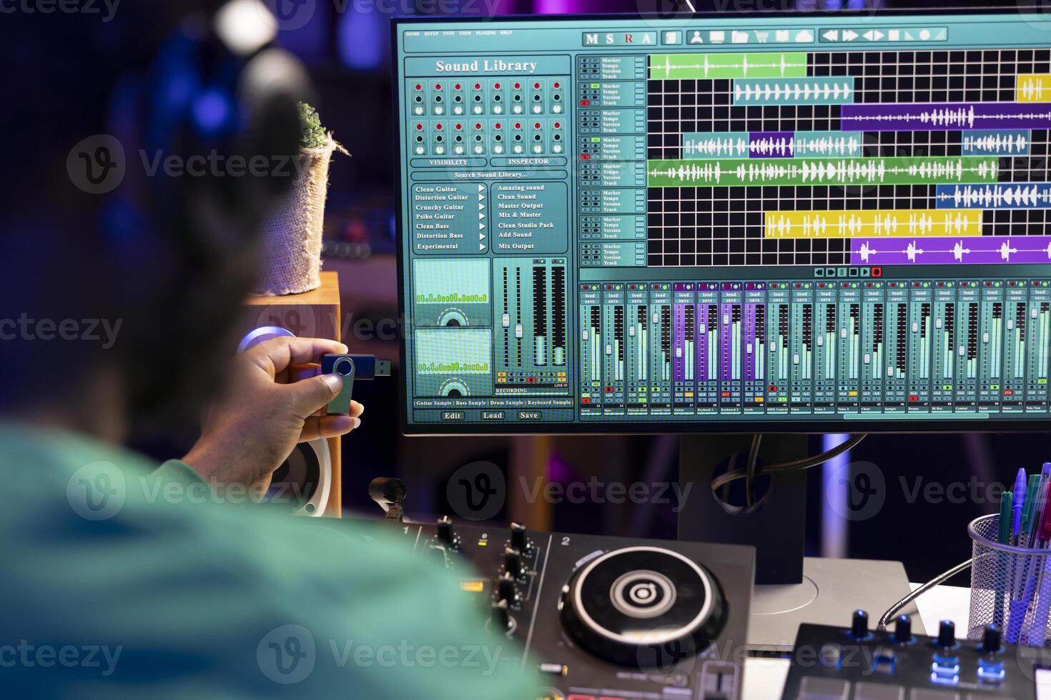 Artist composing new music with an usb stick in his home studio, editing songs from old audio recordings. Skilled songwriter producer mixing and mastering soundtracks, production software. photo
