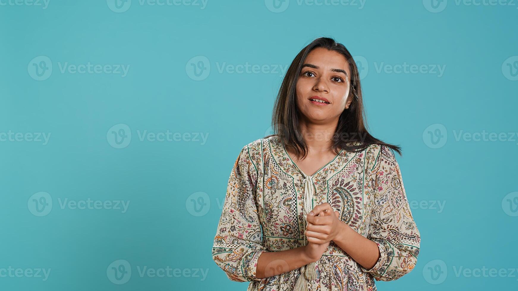 Portrait of jealous indian woman mockingly clapping hands, isolated over studio background. Annoyed person rolling eyes and applauding in jest, doing fake cheering, camera A photo