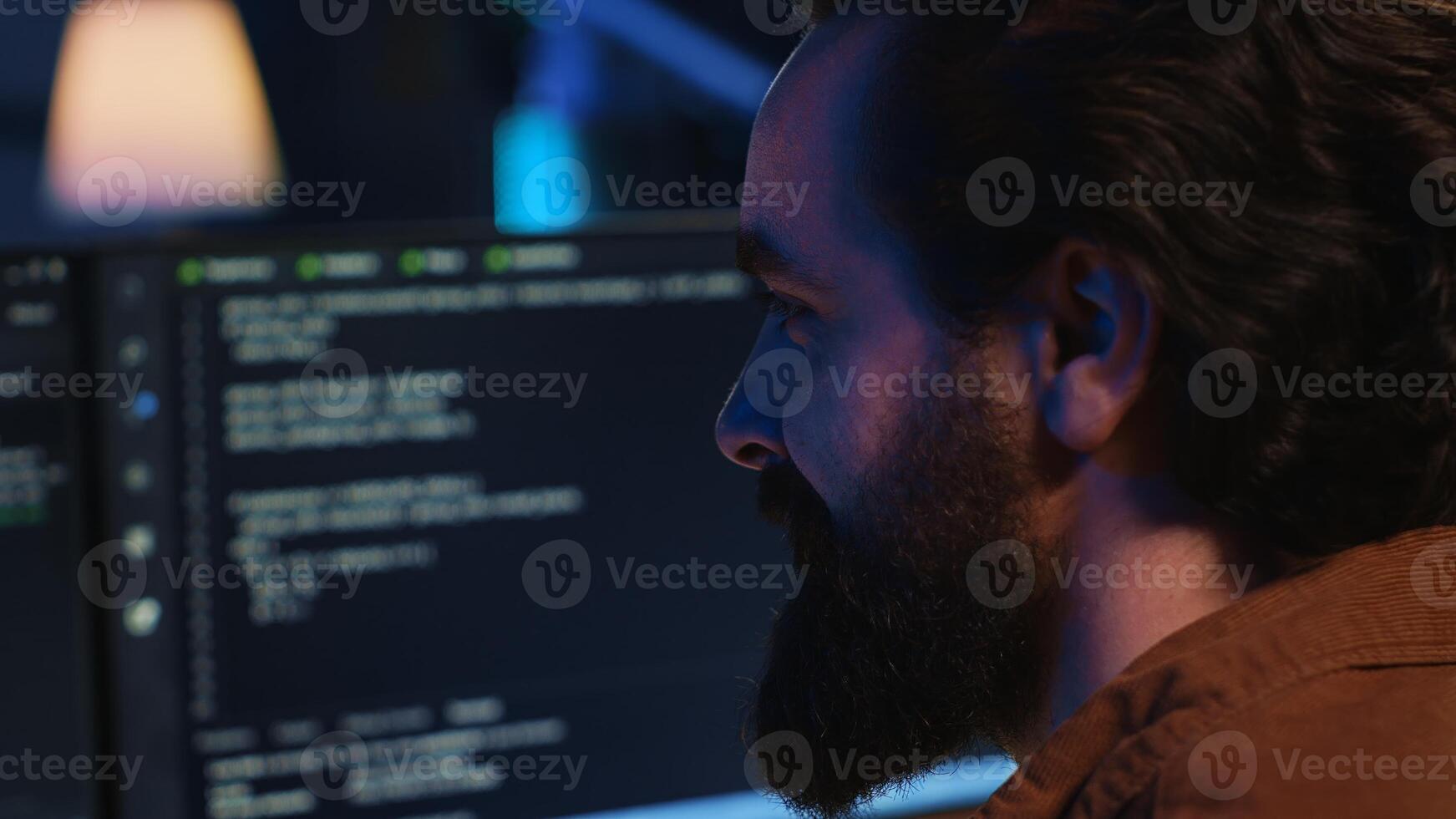 Joyous remotely working programmer in home office doing coding on computer at desk. Upbeat teleworking IT professional in apartment writing lines of code at workstation, camera A close up shot photo