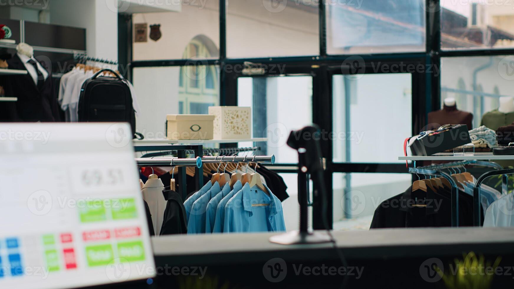 Tailoring boutique filled with new designer clothing line, racks hangers with trendy merchandise and cool accessories or shoes. Empty clothing store with stylish outerwear, small business. Camera A. photo