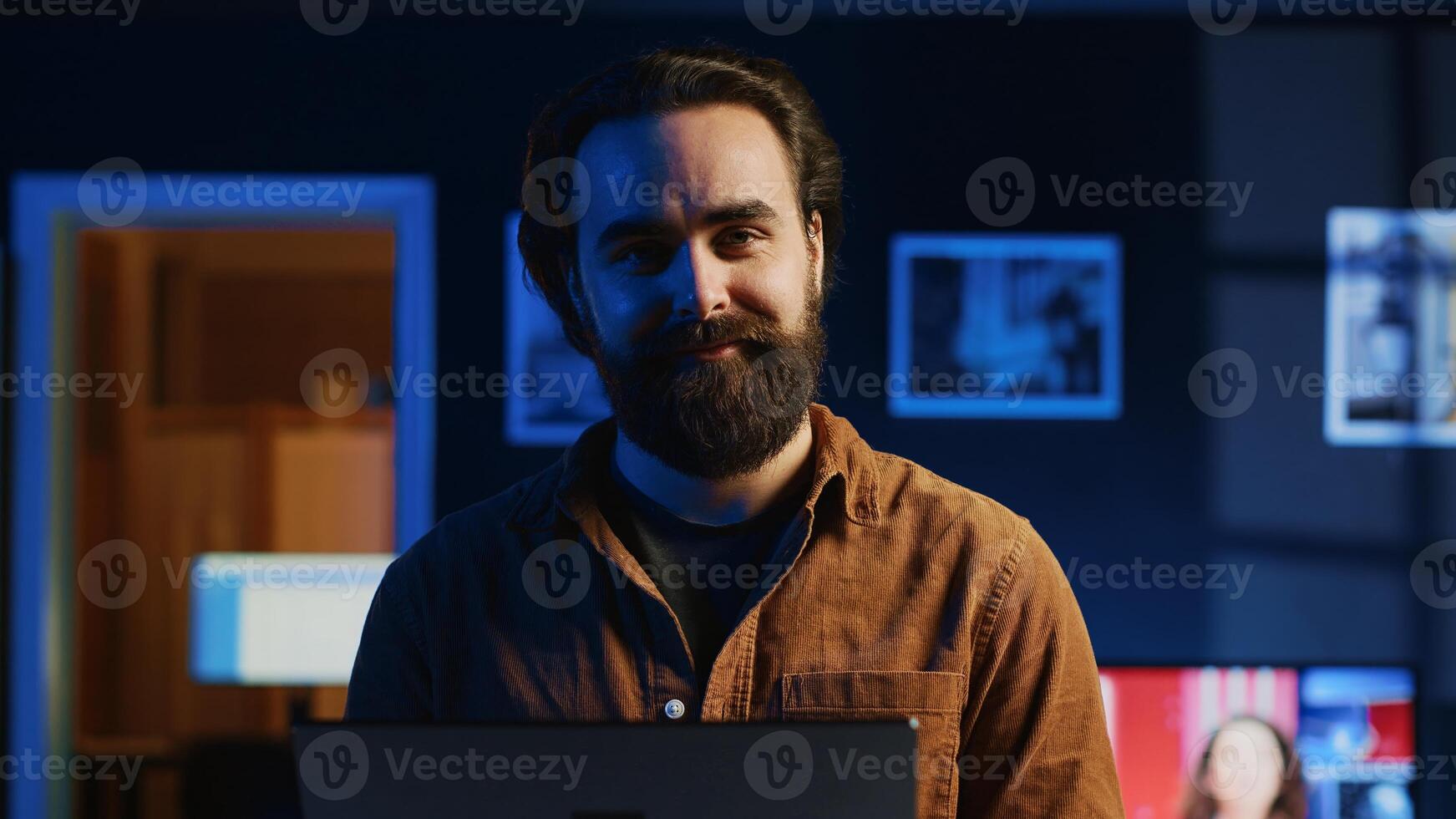 Portrait of happy man doing IT support job from apartment, standing in personal office with laptop in hand, coding. Joyful developer writing lines of code on notebook, camera A close up shot photo