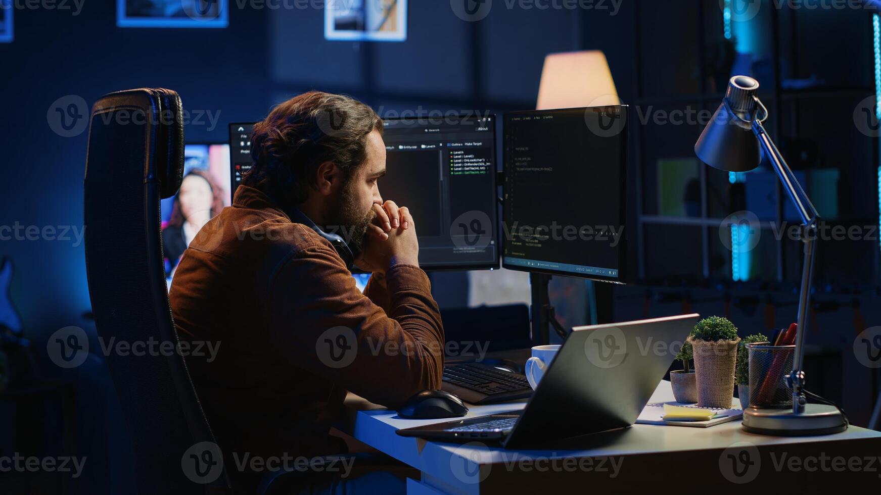 Technician focused on typing complex code in neon lit home office, developing software application. It specialist removing headphones to better concentrate on difficult task, camera A photo