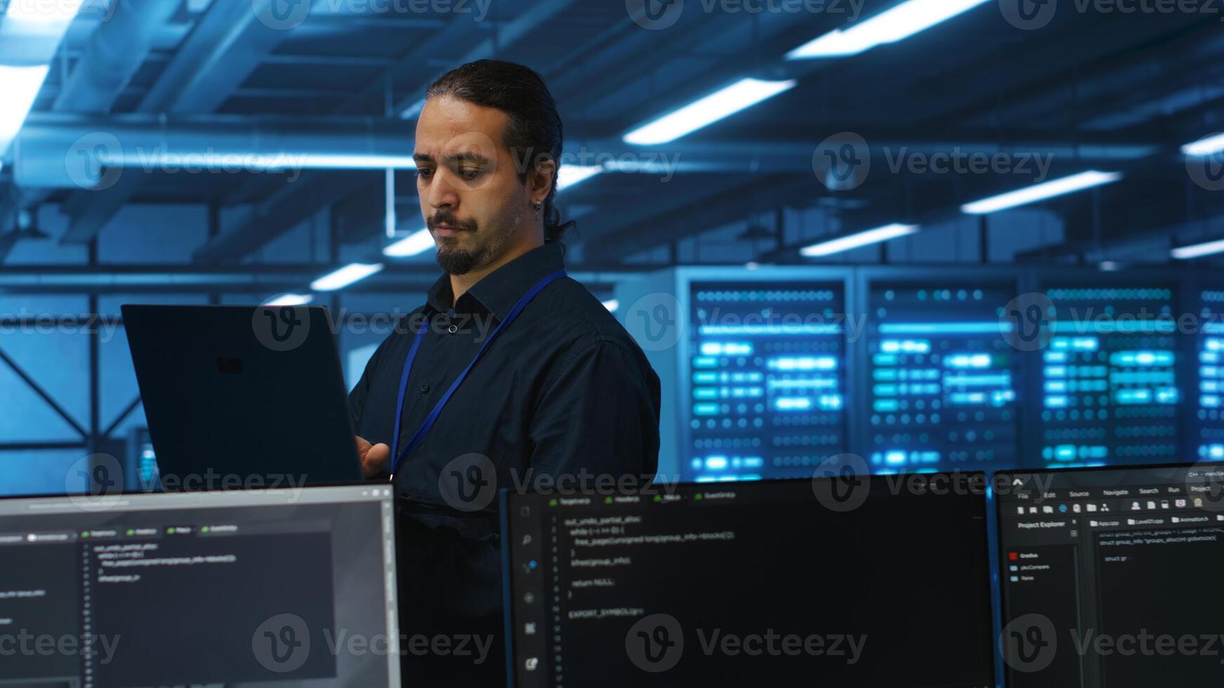 Manager overseeing server room, running code on laptop, troubleshooting and upgrading technologically advanced hardware clusters. System administrator programming in server farm photo