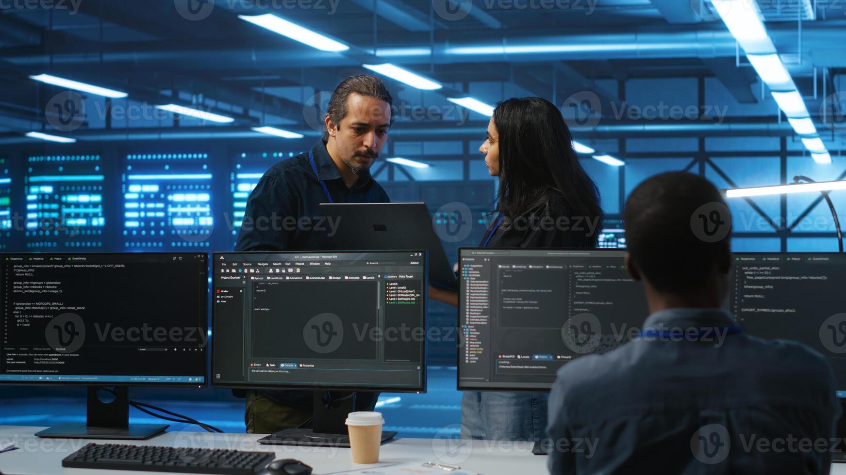 Multiethnic team of admins working in high tech server room capable of storing vast amounts of data. Diverse colleagues doing brainstorming, discussing ways to fix servers photo