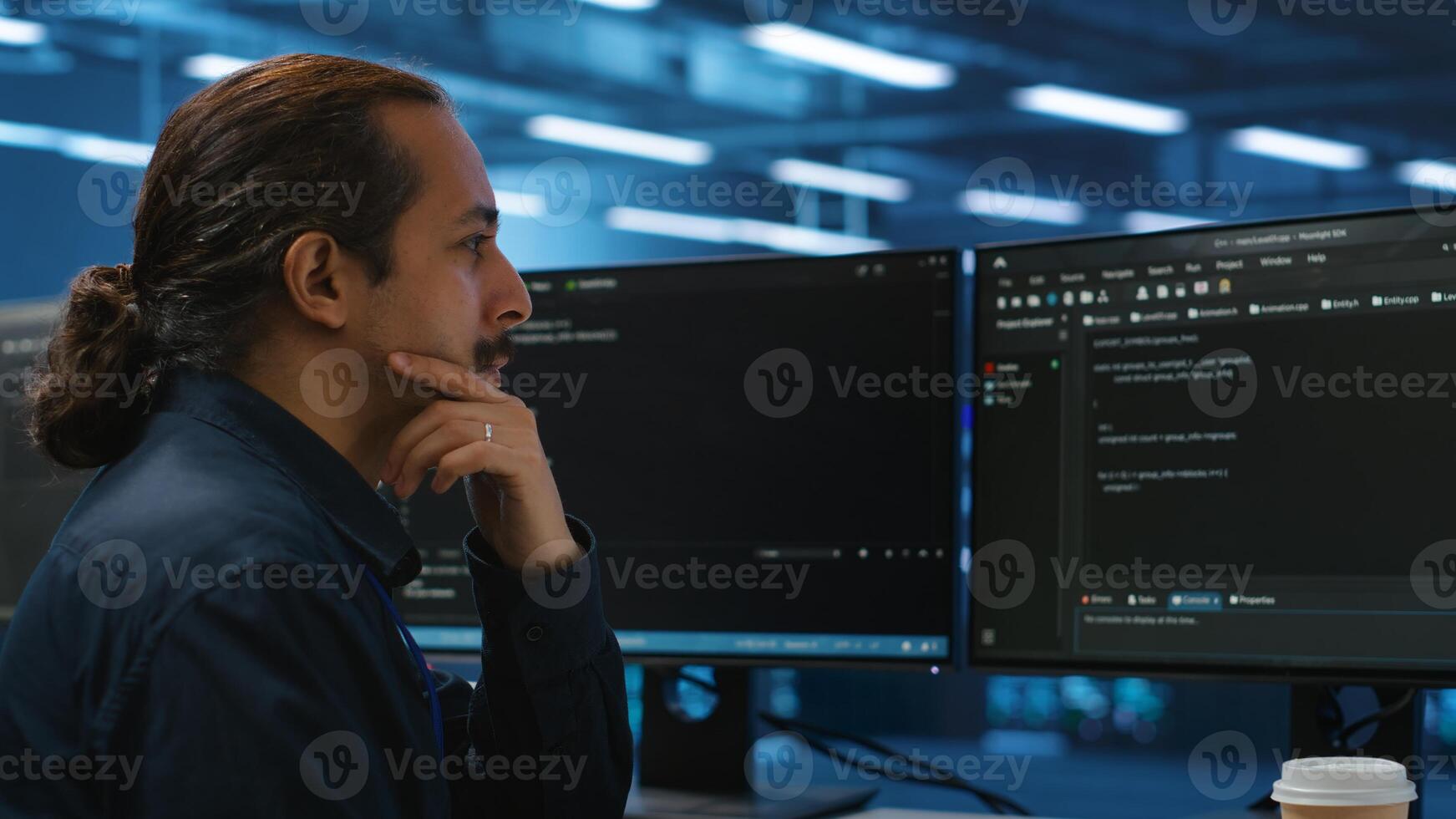Computer scientist in server hub doing system analysis, coding, doing needed adjustments for supercomputers to run. Expert working in data center housing advanced storage infrastructure photo