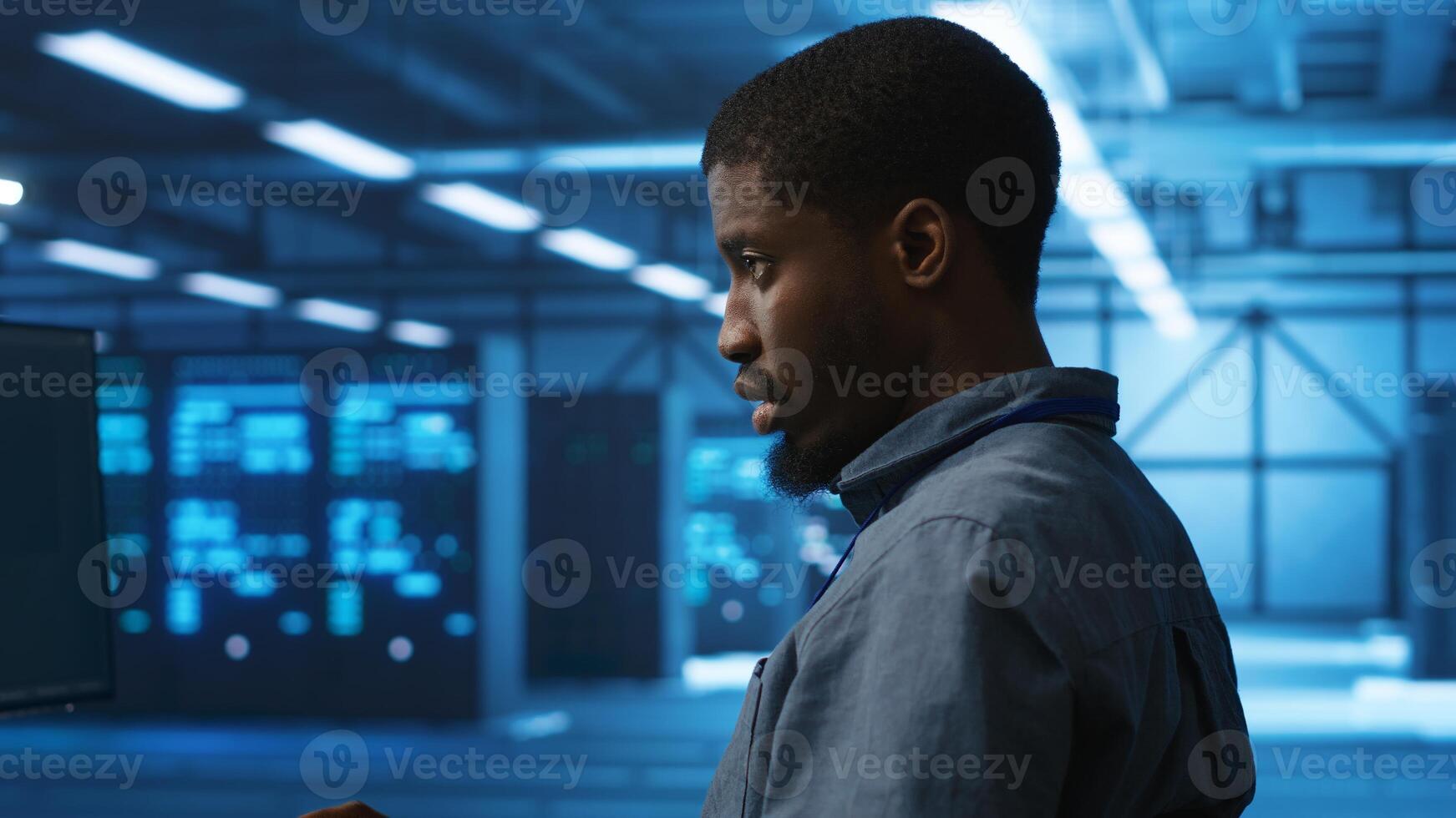 African american man working in server hub capable of processing vast amounts of data. IT programmer at PC desk typing on keyboard, updating servers controlling network resources, close up shot photo
