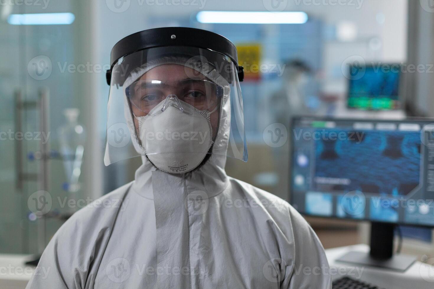 Portrait of biologist researcher in coronavirus protective medical equipment working at healthcare vaccine in biochemical hospital laboratory during biochemistry experiment. Virus investigation photo