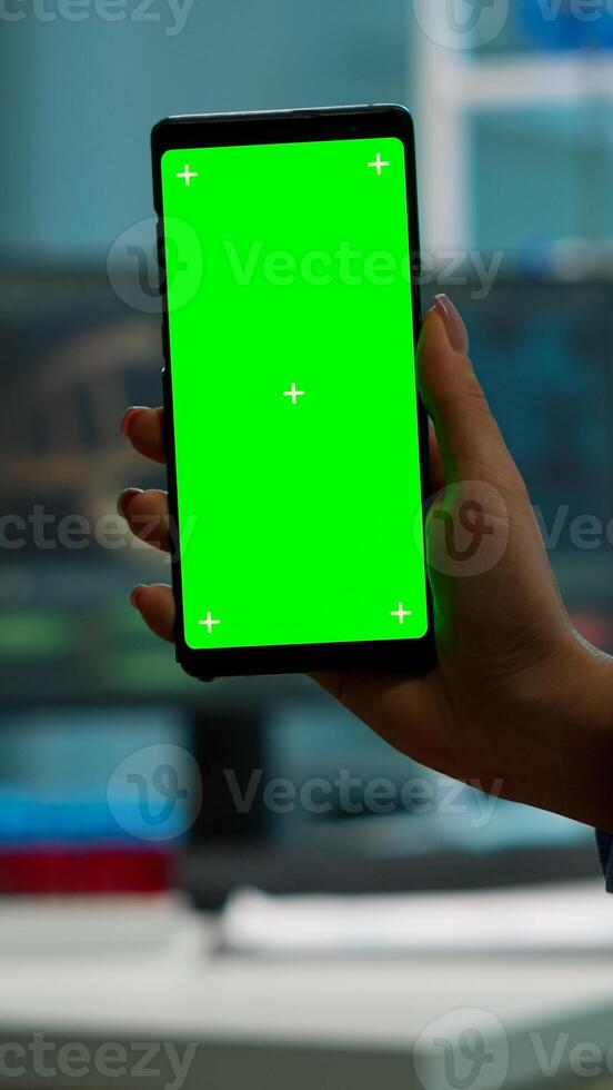 Chroma key isolated display on smartphone used by scientist woman in lab cabinet and colleagues in white coat bringing blood sample. Scientist using mobile phone with mockup green screen photo