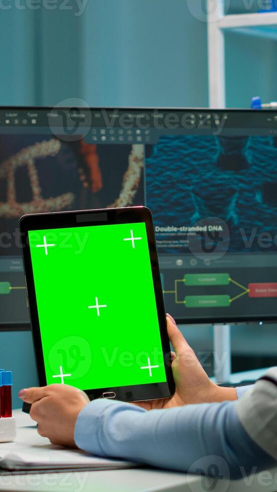 Medical research laboratory portrait of female scientist holding tablet with green chroma key screen. Advanced scientific lab for medicine, biotechnology working for vaccine development. photo