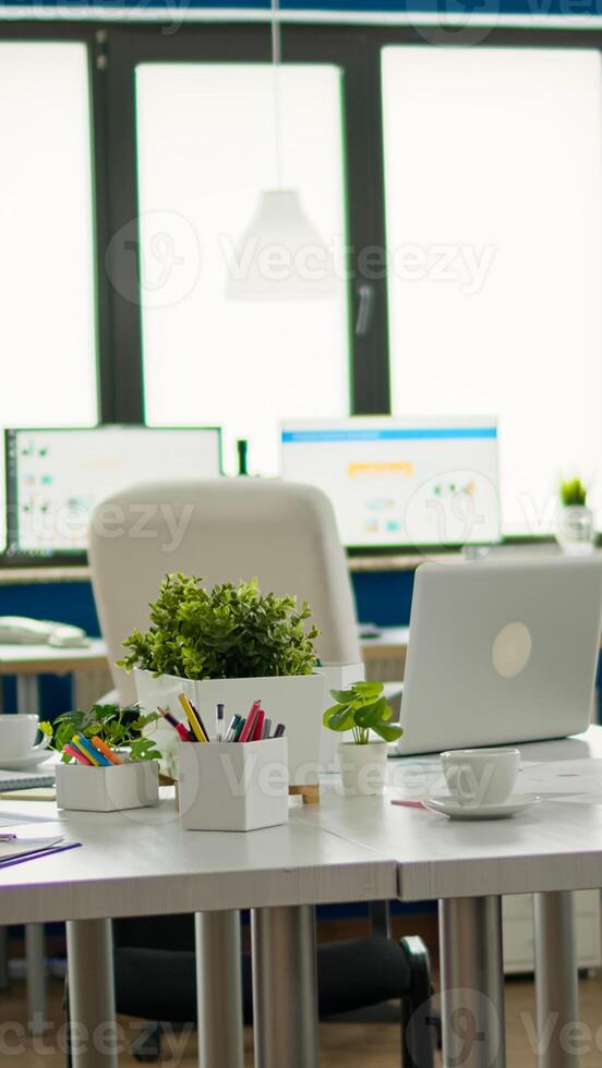 Interior of cozy light company room with conference table ready for brainstorming, modern stylish chairs and desktop monitor, all ready for employees. Empty spacious office of creative working space. photo