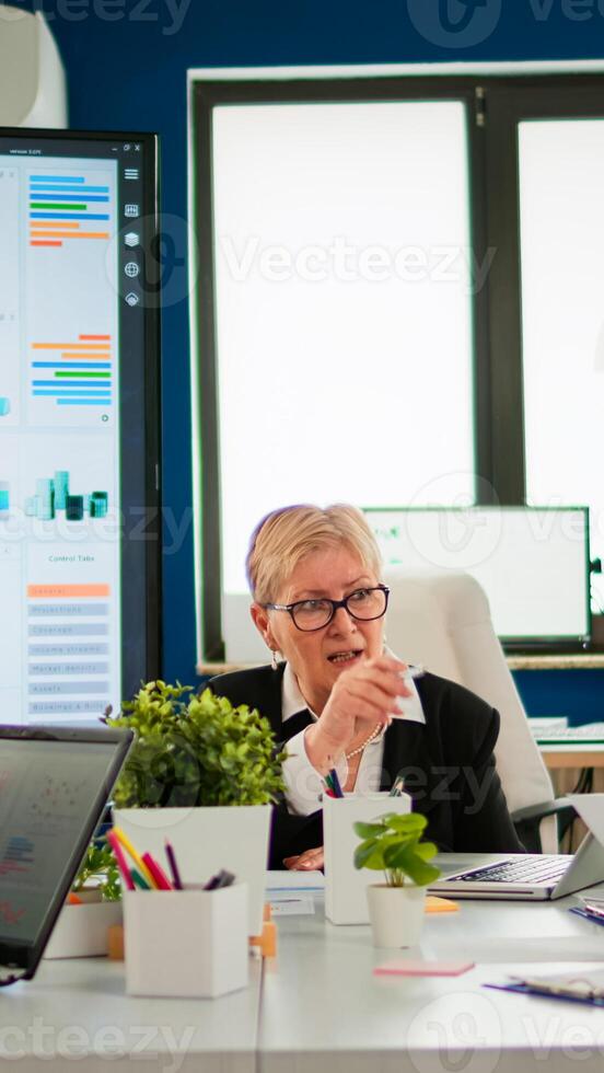 Group of diverse business people discussing with partners on call during meeting sitting in conference room. Internet conference call technology talk with investors, corporate brainstorming via web photo