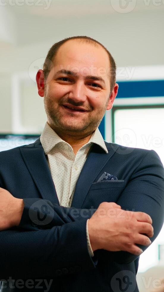 Young man project manager smiling in front of camera standing in brainstorming room, preparing for meeting with partners. Businessman working in professional start up financial business ready for conference photo