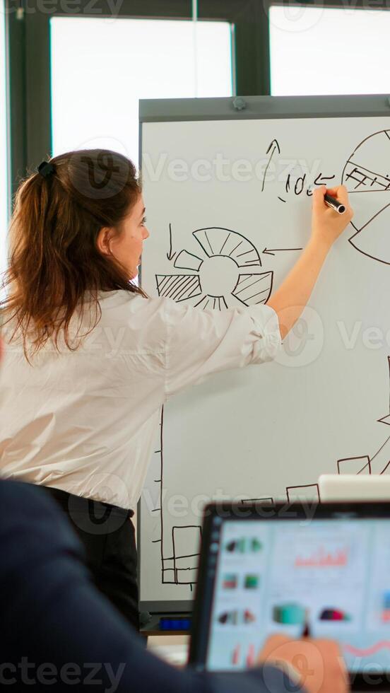 Company head standing in front of audience diverse staff members making presentation using flip chart raised sales positive results of work done, seminar corporate education concept photo