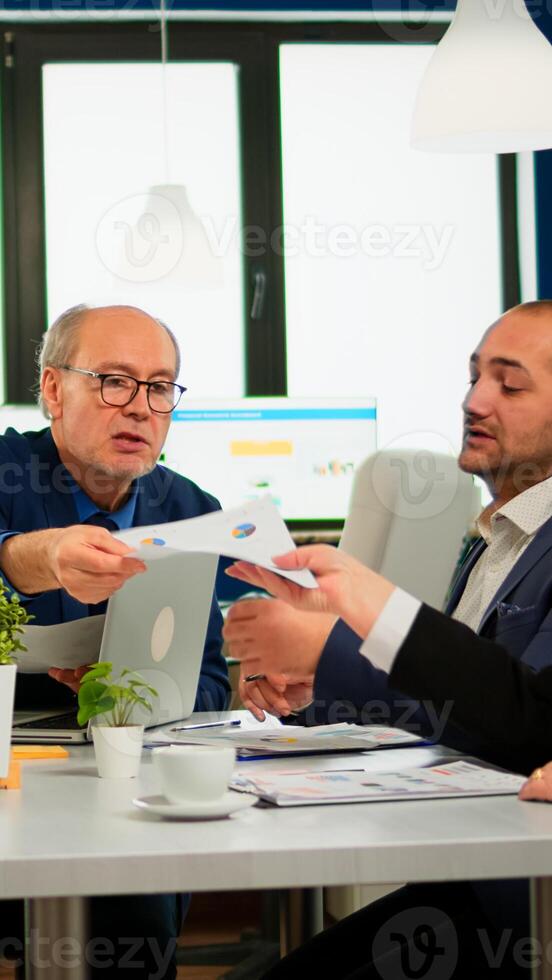 Smart team of multiethnic people using documents in planning for meeting, secretary female bring documents to boss during conference. Manager briefing diverse teamworkers during brainstorming. photo