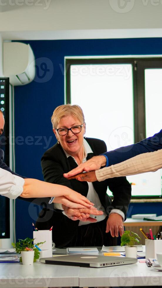 Overjoyed multiethnic company team throwing up hands celebrating successful project, receving good news. Happy diverse colleagues with new business opportunity enjoing victory photo