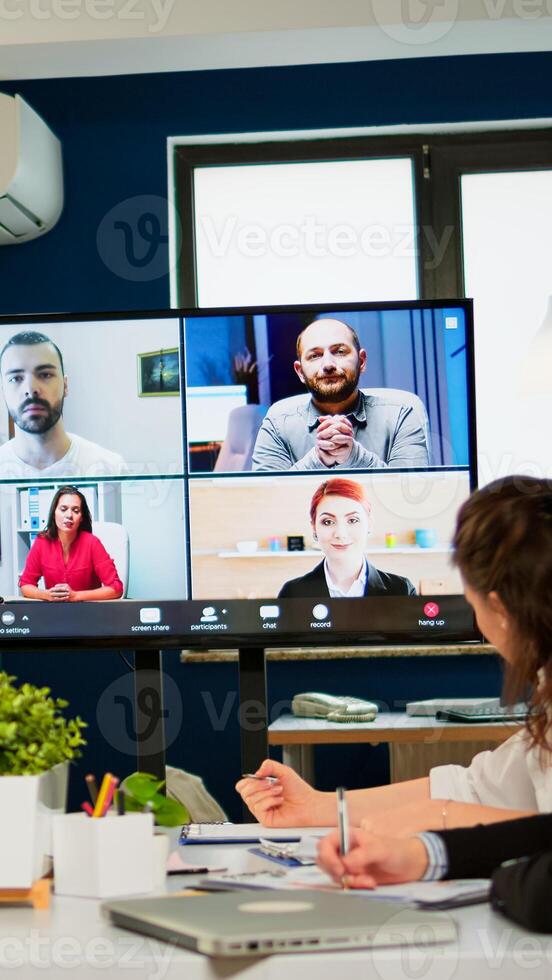 Headshot screen application view of remote multiracial employees talking on call brainstorm together multiethnic coworkers engaged in team discussion online using web conference, virtual meeting photo