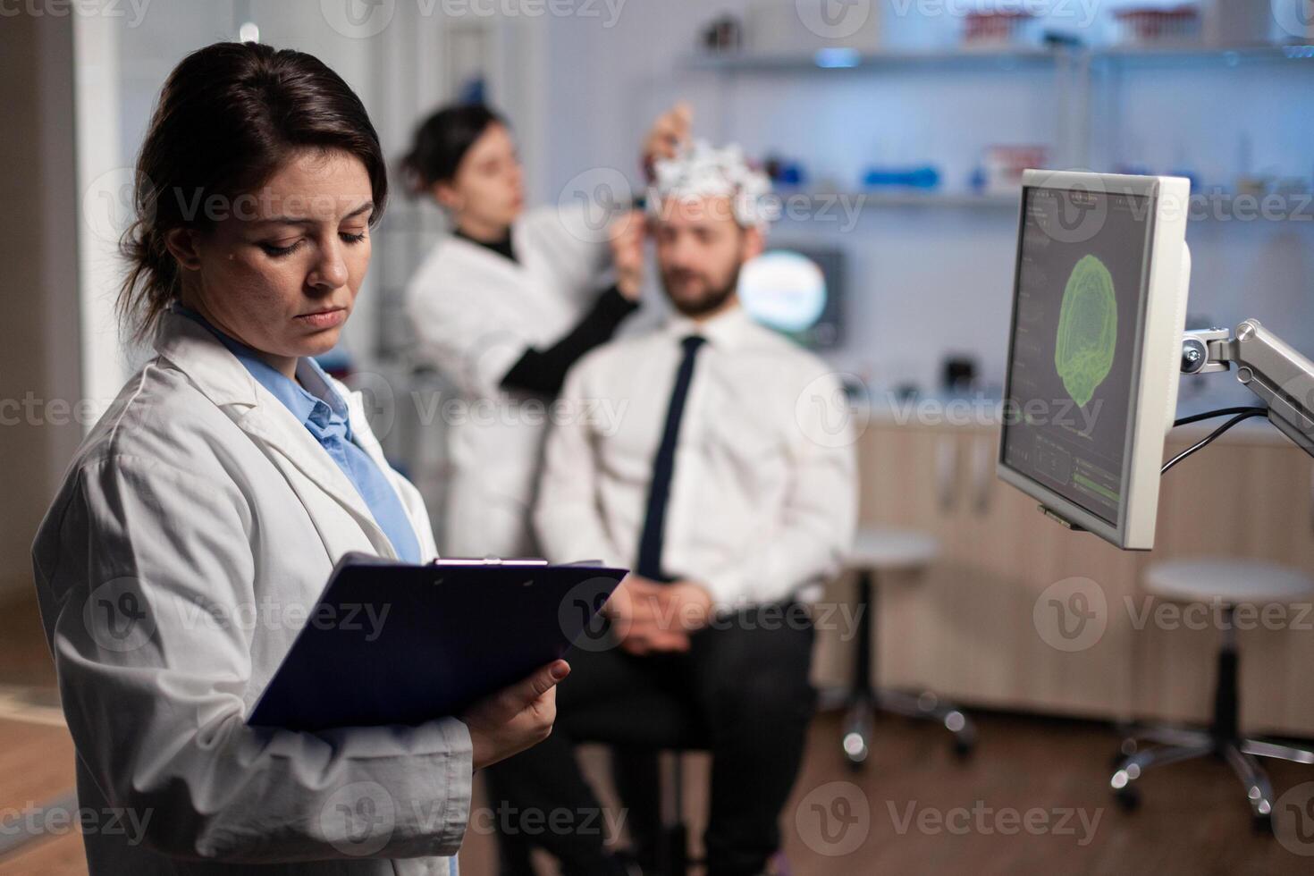 Medical neurologist woman adjusting eeg headset monitoring brain activity of man patient during medical experiment in modern laboratory. Scientist engineer analyzing nervous system photo