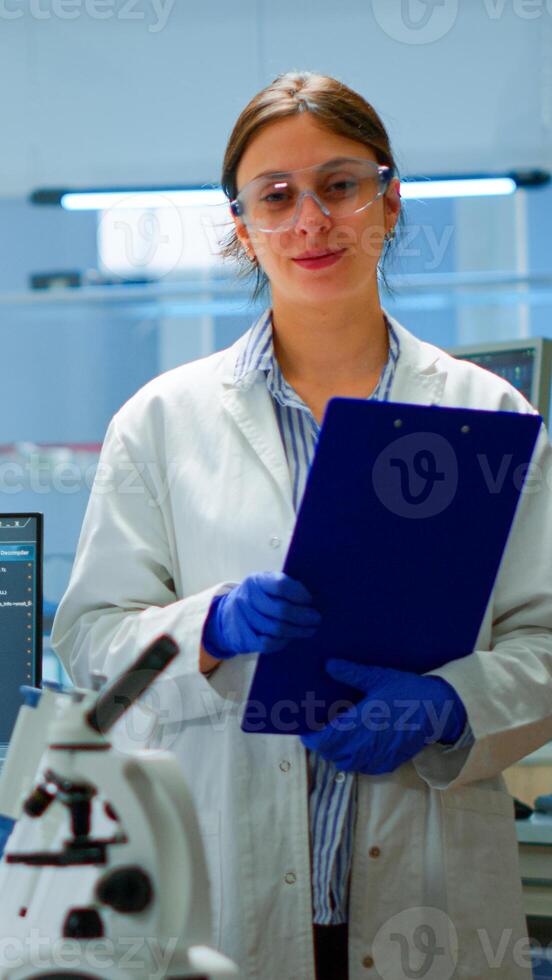 Professional scientific medical staff looking at camera in modern equipped lab. Team of doctors examining virus evolution with high tech, chemistry tools for scientific research, vaccine development photo