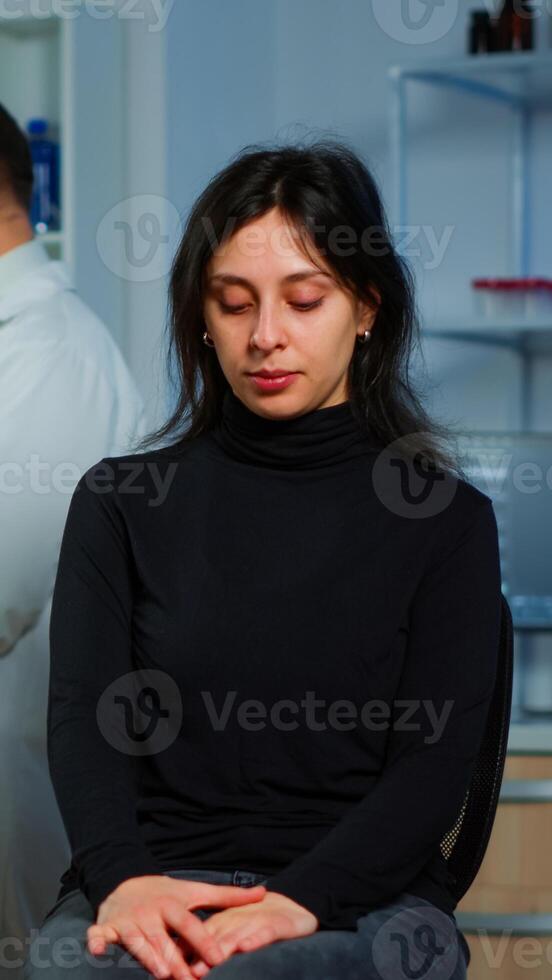 Team of scientists doctor discussing health status of patient, brain functions, nervous system, tomography scan while woman waiting for diagnosis of disease sitting in neurological research laboratory photo