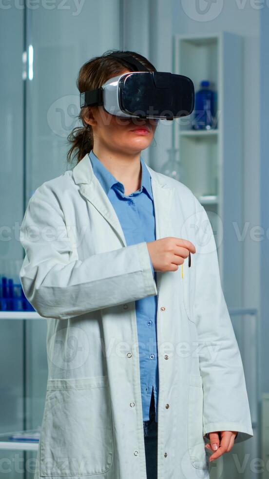 Professional researcher wearing virtual reality glasses using medical inovation in lab analysing brain scan of patient. Team of neurological doctors working with equipment high tech simulator device photo