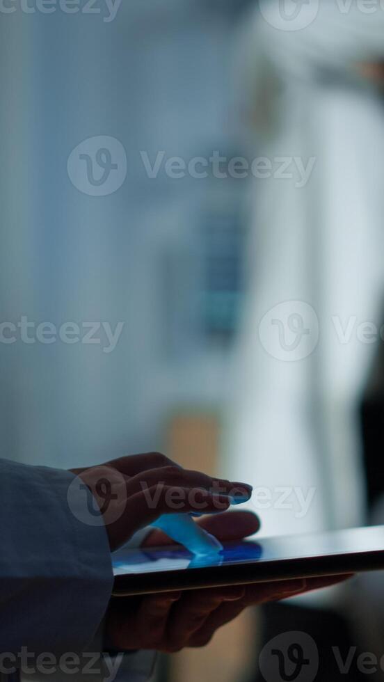 Close up of expert scientist in neurological dysfunctions standing in laboratory working at tablet. Medical researcher preparing patient for brain scan analysing electrical activity of nervous system photo